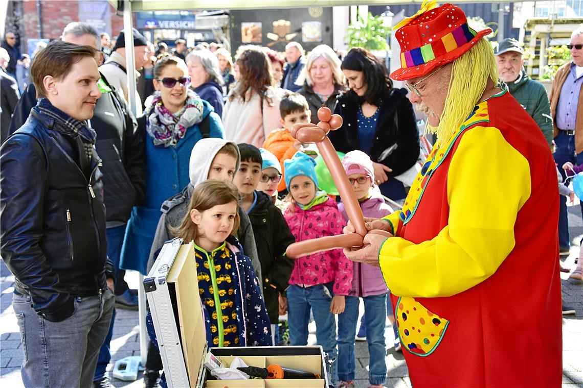 Ein Clown bastelt Luftballonfiguren für die Kinder.