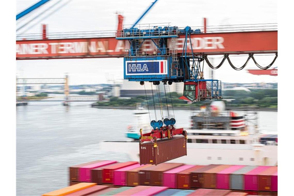 Ein Container wird auf dem Terminal Altenwerder im Hamburger Hafen auf ein Schiff geladen. Deutschlands Exporteure arbeiten sich langsam aus dem Corona-Tief. Foto: Daniel Reinhardt/dpa