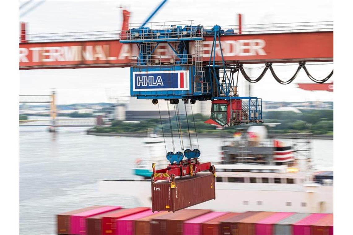 Ein Container wird im Hamburger Hafen auf ein Schiff geladen. Foto: Daniel Reinhardt/dpa