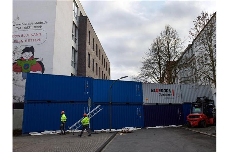 Ein Containerwand zur Minderung einer möglichen Druckwelle wird im Klinikviertel vor dem Institut für Transfusionsmedizin des Klinikums Dortmund errichtet. Foto: Bernd Thissen/dpa