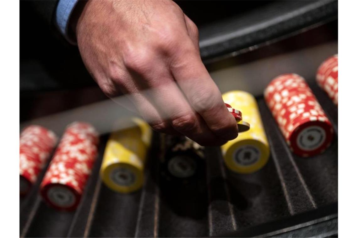 Ein Croupier hält in der Spielbank Stuttgart während eines Pressetermins Jetons in der Hand. Foto: Marijan Murat/dpa/Illustration