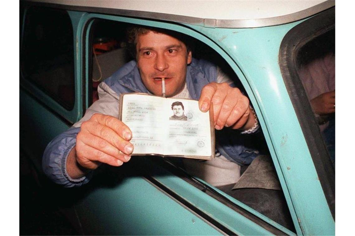 Umfrage: Jeder siebte Deutsche sieht Mauerfall kritisch Ein DDR-Bürger zeigt bei der ersten freien Fahrt in die BRD seinen Ausweis vor. Foto: Holger Hollemann/dpa