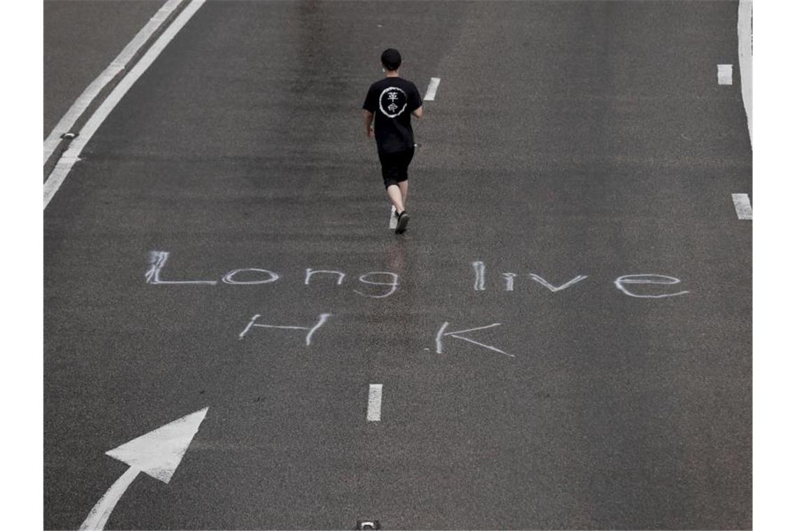 Ein Demonstrant auf einer Straße, auf der „Long live HK“ (Lang lebe Hongkong) steht. Foto: Kin Cheung/AP