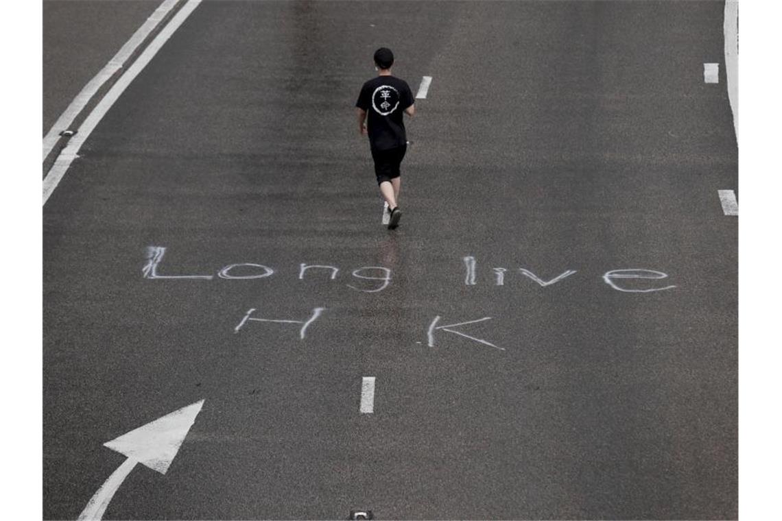 Hongkongs Regierungschefin verurteilt Angriff auf Parlament Ein Demonstrant auf einer Straße, auf der „Long live HK“ (Lang lebe Hongkong) steht. Foto: Kin Cheung/AP