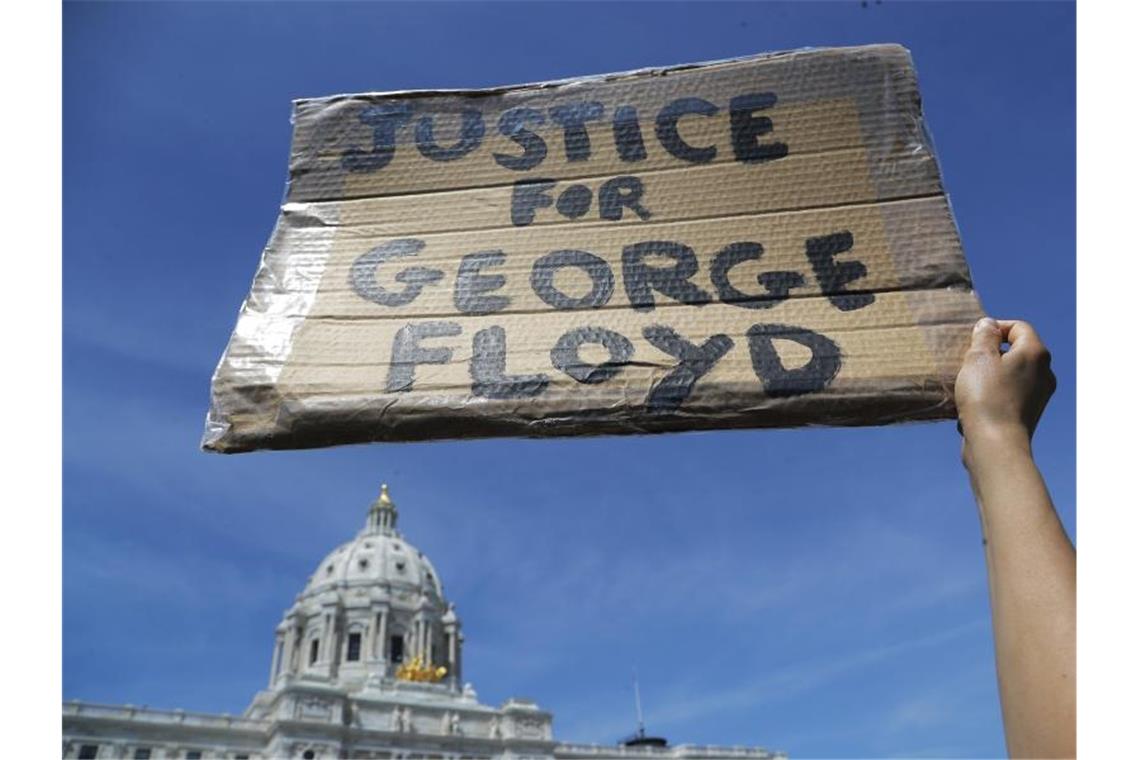 Ein Demonstrant fordert mit einem Plakat „Gerechtigkeit für George Floyd“ vor dem Minnesota Statehouse. Foto: Julio Cortez/AP/dpa