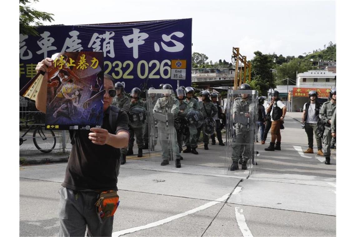 Hongkong: Zusammenstöße zwischen Polizei und Demonstranten Ein Demonstrant hält ein Poster hoch, auf dem steht: "Stoppen Sie die Gewalt". Foto: Vincent Yu/AP