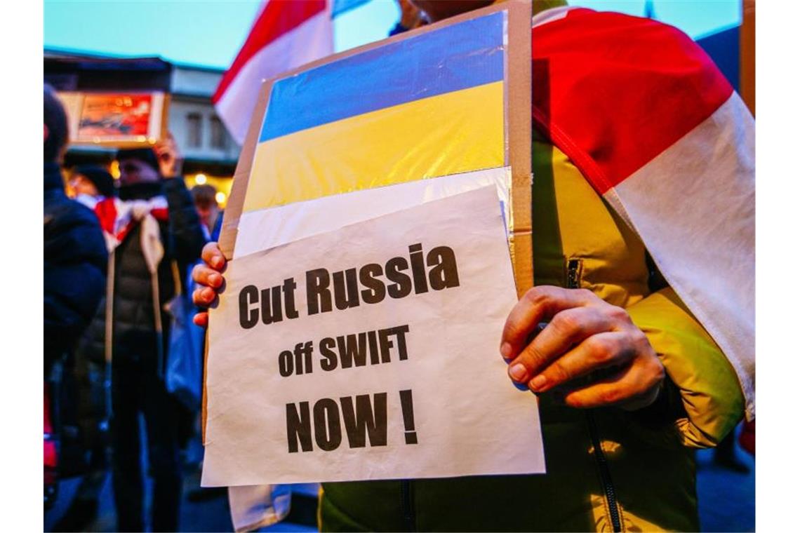 Swift: Verbündete beschließen Ausschluss russischer Banken Ein Demonstrant hält ein Schild mit der ukrainischen Flagge und der Aufschrift „Russland jetzt abschneiden!“. Foto: Filip Radwanski/SOPA Images via ZUMA Press Wire/dpa