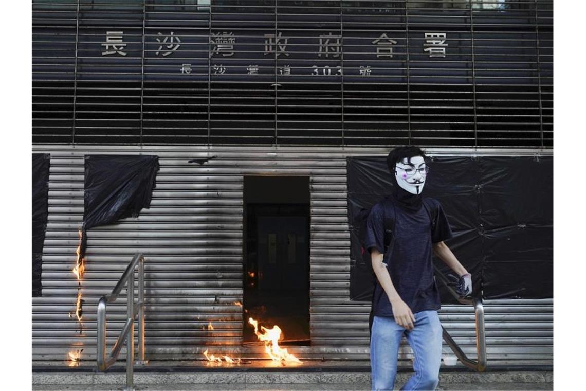 Ein Demonstrant hat einen Molotow-Cocktail auf den verschlossenen Eingang einer U-Bahn-Station geworfen. Foto: Vincent Yu/AP/dpa