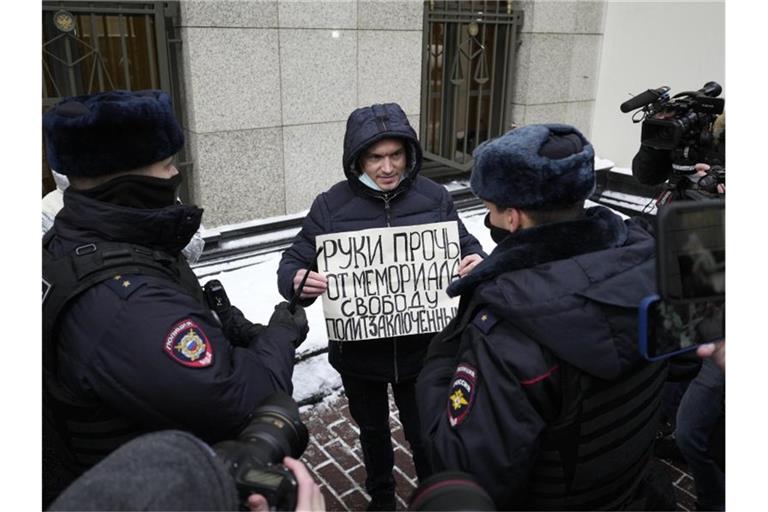 Ein Demonstrant im Beisein der Polizei, der Mitte Dezember in Moskau gegen die gerichtliche Verfügung protestiert. Foto: Pavel Golovkin/AP/dpa