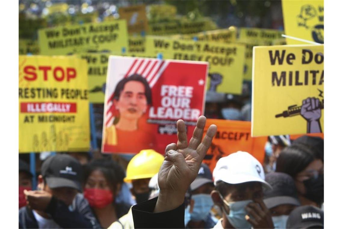 Proteste in Myanmar fortgesetzt - Polizei greift durch Ein Demonstrant macht den Drei-Finger-Gruß während Protesten in Mandalay gegen den Putsch der Militärjunta. Foto: -/AP/dpa
