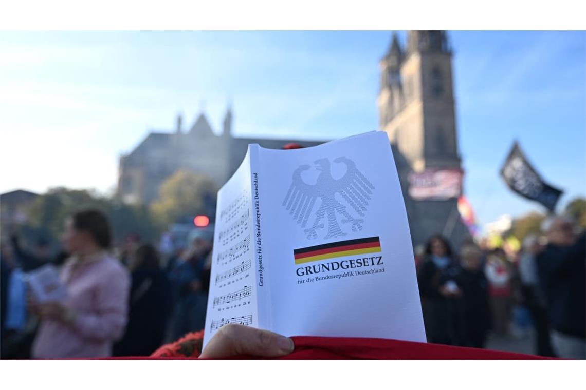 Ein Demonstrant protestiert mit dem Grundgesetz in der Hand vor der konstituierenden Sitzung des Landtags von Sachsen-Anhalt.