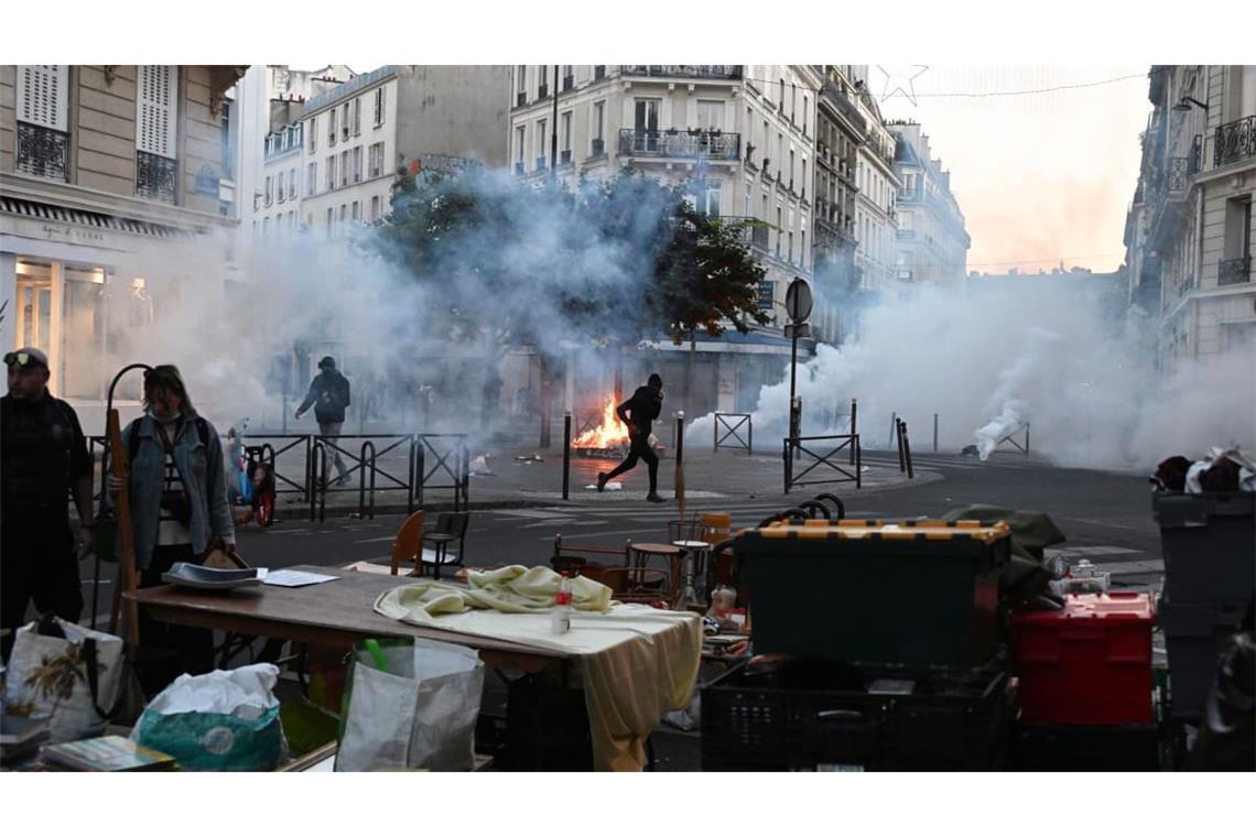 Ein Demonstrant rennt durch Tränengas, während es auf einem Flohmarkt erneut Zusammenstöße zwischen Demonstranten und Polizeibeamten in Paris dibt.