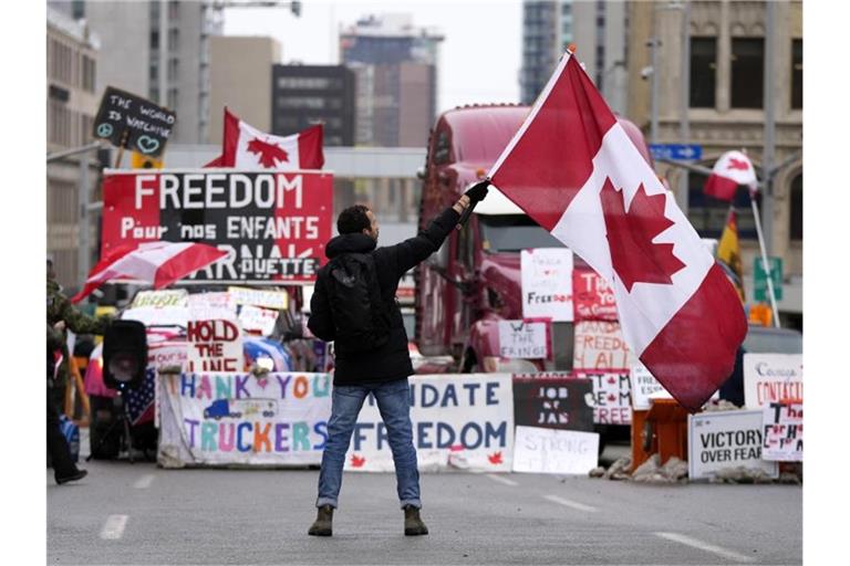 Ein Demonstrant schwenkt bei einem Protest gegen die Corona-Maßnahmen in Ottawa eine kanadische Flagge. Foto: Justin Tang/The Canadian Press/dpa