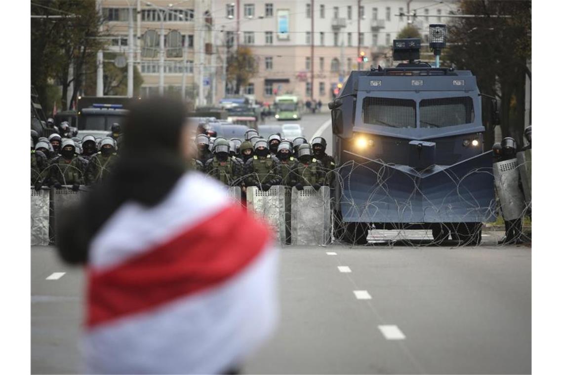 Polizei in Belarus setzt und Blend- und Lärmgranaten ein Ein Demonstrant steht in Minsk einer Reihe von Polizisten gegenüber. Foto: Uncredited/AP/dpa
