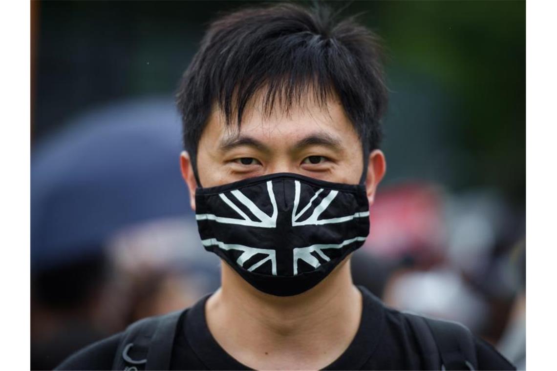 Ein Demonstrant trägt auf dem zentralen Ort der Kundgebung im Victoria Park einen Mundschutz mit der britischen Flagge. Foto: Gregor Fischer