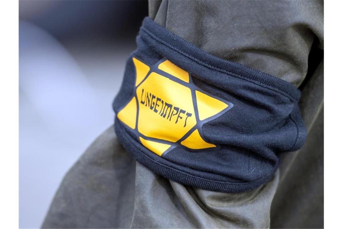 Ein Demonstrant trägt eine Armbinde mit einem gelben Stern mit der Aufschrift „Ungeimpft“. Foto: Christophe Gateau/dpa/Archivbild