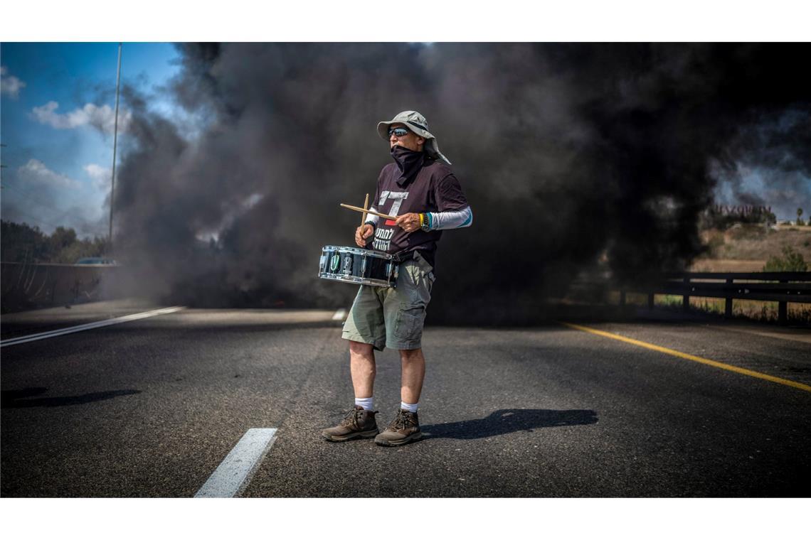 Ein Demonstrant trommelt bei einer Straßenblockade in Israel für die sofortige Freilassung aller von der Terrororganisation Hamas festgehaltenen Geiseln und das Ende des Krieges im Gazastreifen.