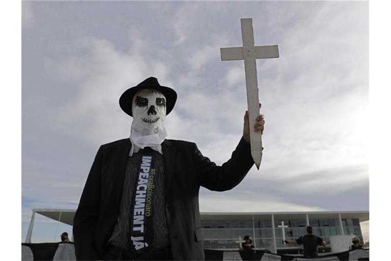Ein Demonstrant vor dem Präsidentenpalast in Brasilia. Der Protest richtet sich gegen die Regierung im Umgang mit der Corona-Pandemie. Foto: Eraldo Peres/AP/dpa