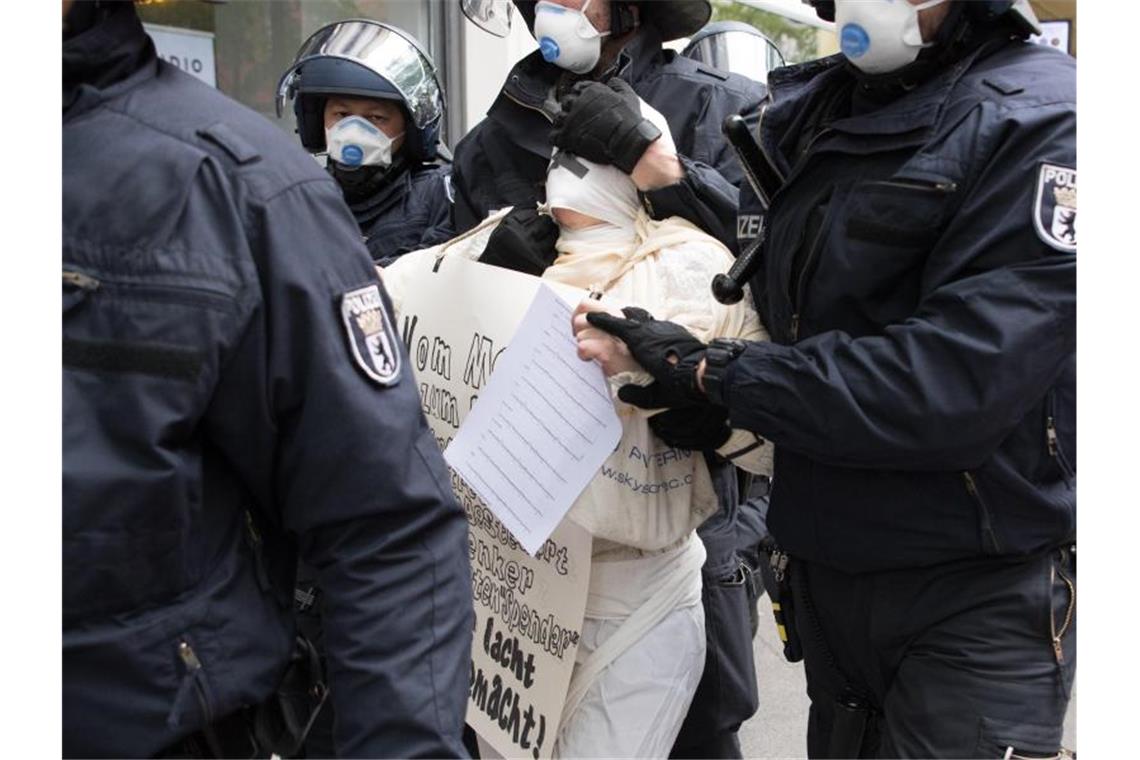 Ein Demonstrant wird bei der Kundgebung in Berlin abgeführt. Foto: Jörg Carstensen/dpa