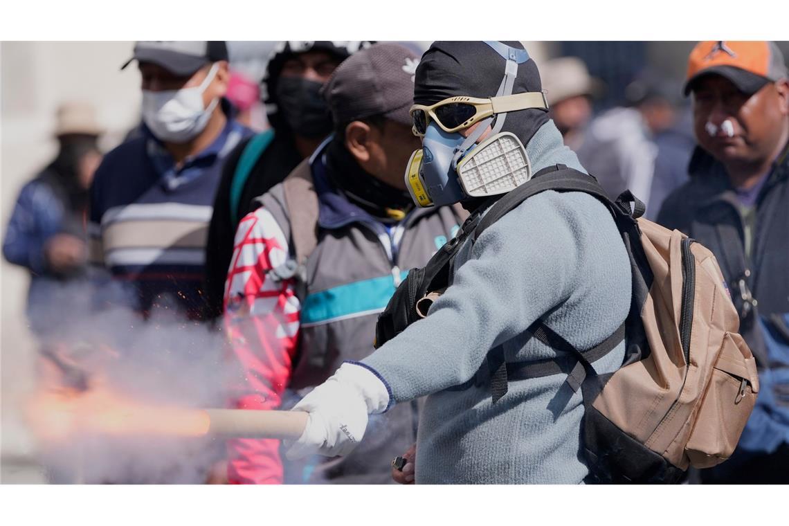 Ein Demonstrant wirft einen Feuerwerkskörper auf die Polizei.