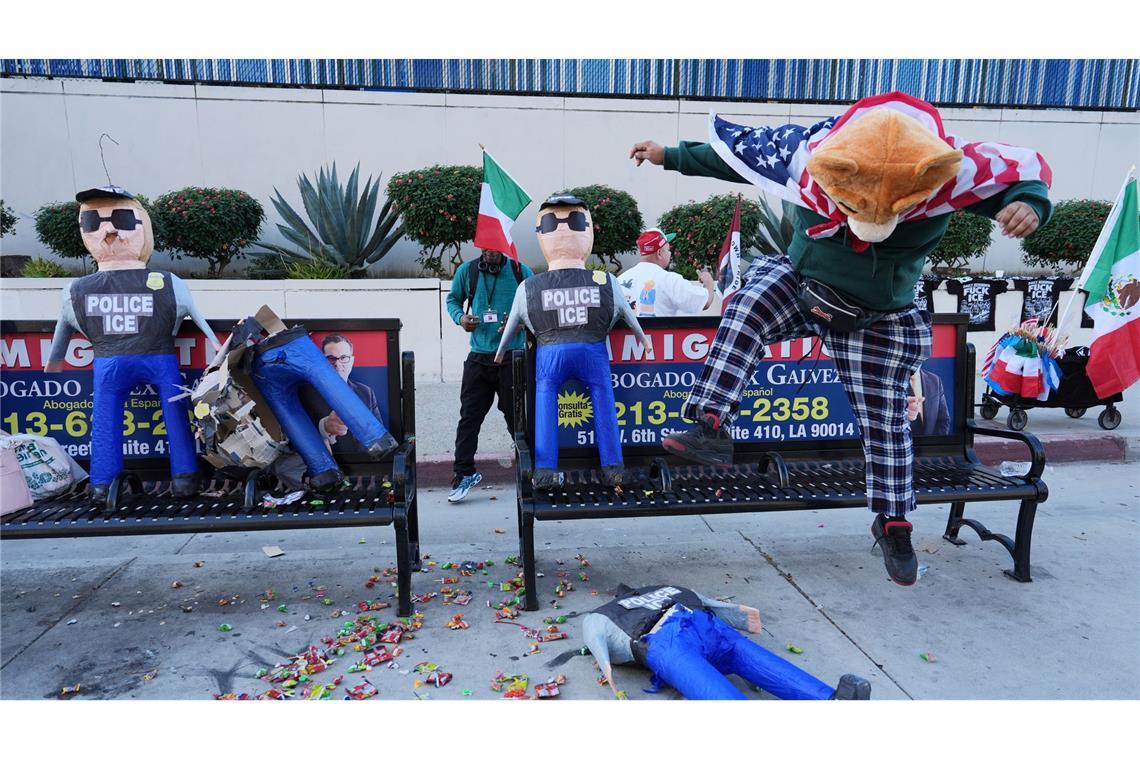 Ein Demonstrant zerschlägt eine Piñata in Form eines ICE-Agenten.