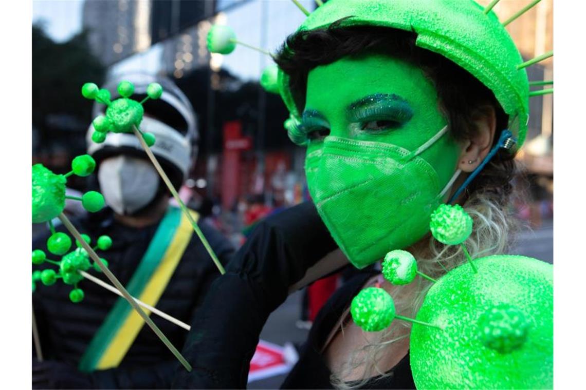 Ein Demonstrantin hat sich ihr Gesicht grün geschminkt und trägt eine grüne Schutzmaske. Tausende Brasilianer sind erneut gegen die Corona-Politik der Regierung von Bolsonaro auf die Straße gegangen. Foto: Dario Oliveira/ZUMA Press Wire/dpa