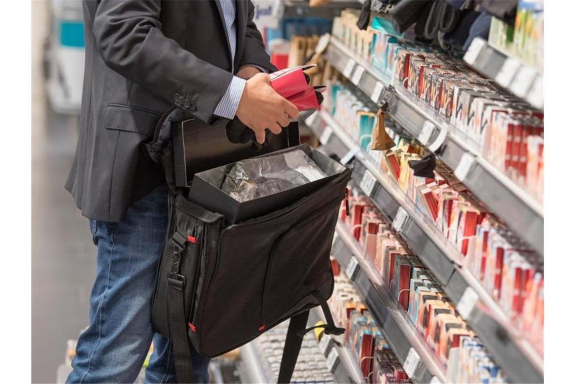 Ein Detektiv einer Sicherheitsfirma demonstriert, wie Ladendiebe mit Hilfe eines präparierten Koffers die Sicherungsetiketten an der Ware überlisten können. Foto: Boris Roessler/dpa