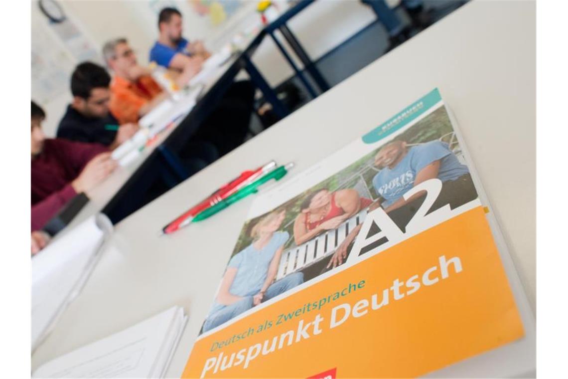 Ein Deutschbuch liegt in einem Integrationskurs (BAMF-Kurs) an einer Sprachschule auf dem Tisch. Foto: Julian Stratenschulte/dpa/Archivbild