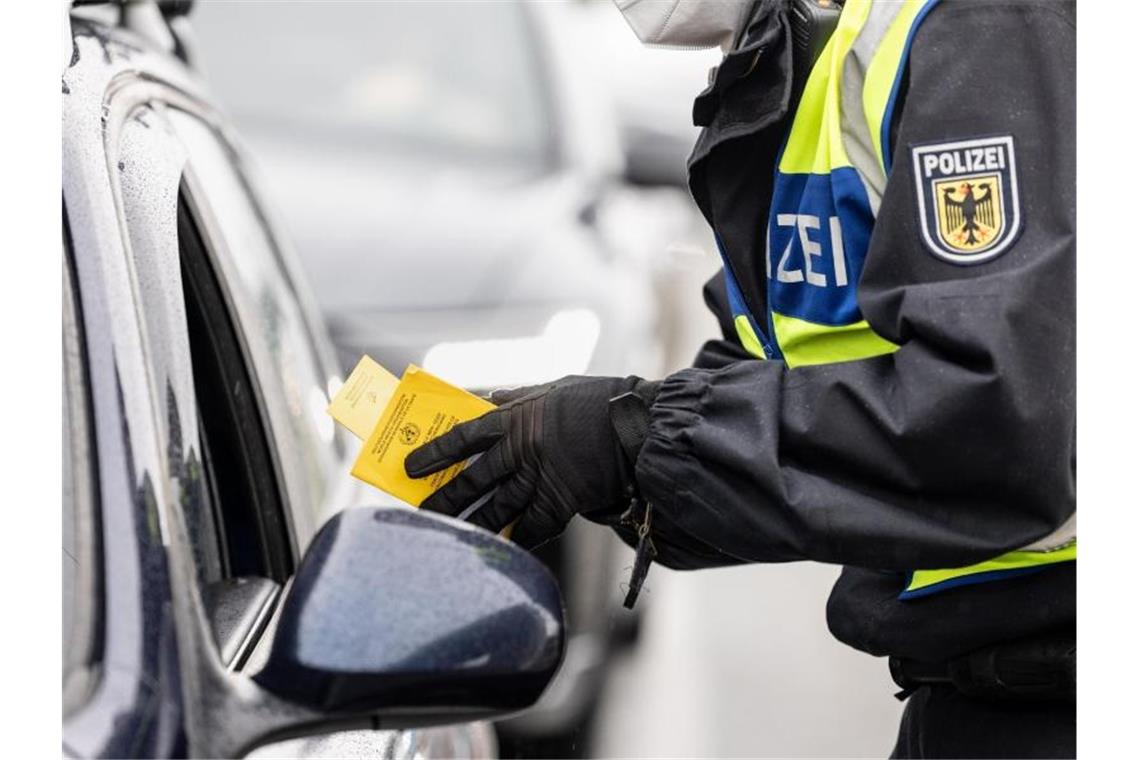 Angehender Bundespolizist bringt sich mit „Like“ um den Job Ein deutscher Bundespolizist kontrolliert an der Grenze zu Österreich den Impfpass einer einreisenden Person. Foto: Matthias Balk/dpa