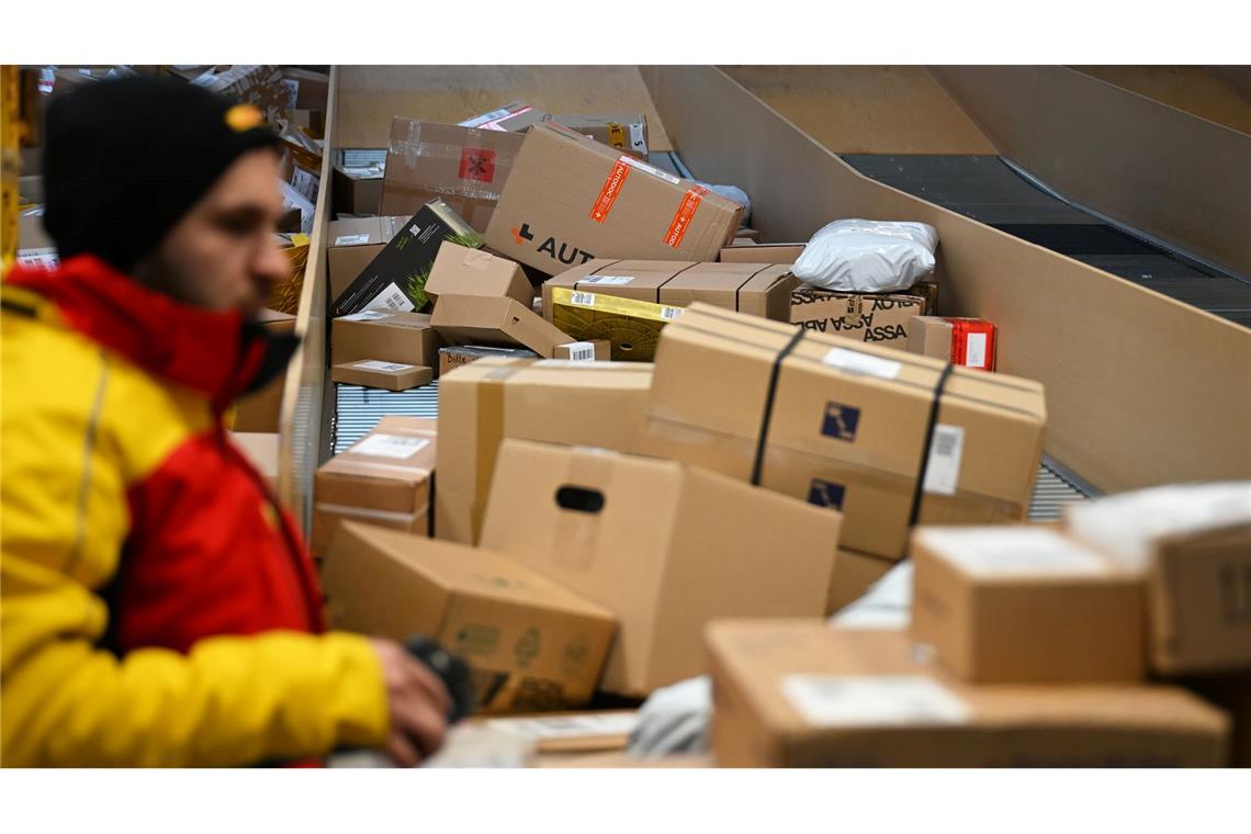 Ein DHL-Paketbote ist in einer Zustellbasis mit einer Vielzahl an Paketen beschäftigt. Der Logistikkonzern hat Jahreszahlen für 2025 vorgelegt, er hat profitablere Geschäfte gemacht als zuvor.