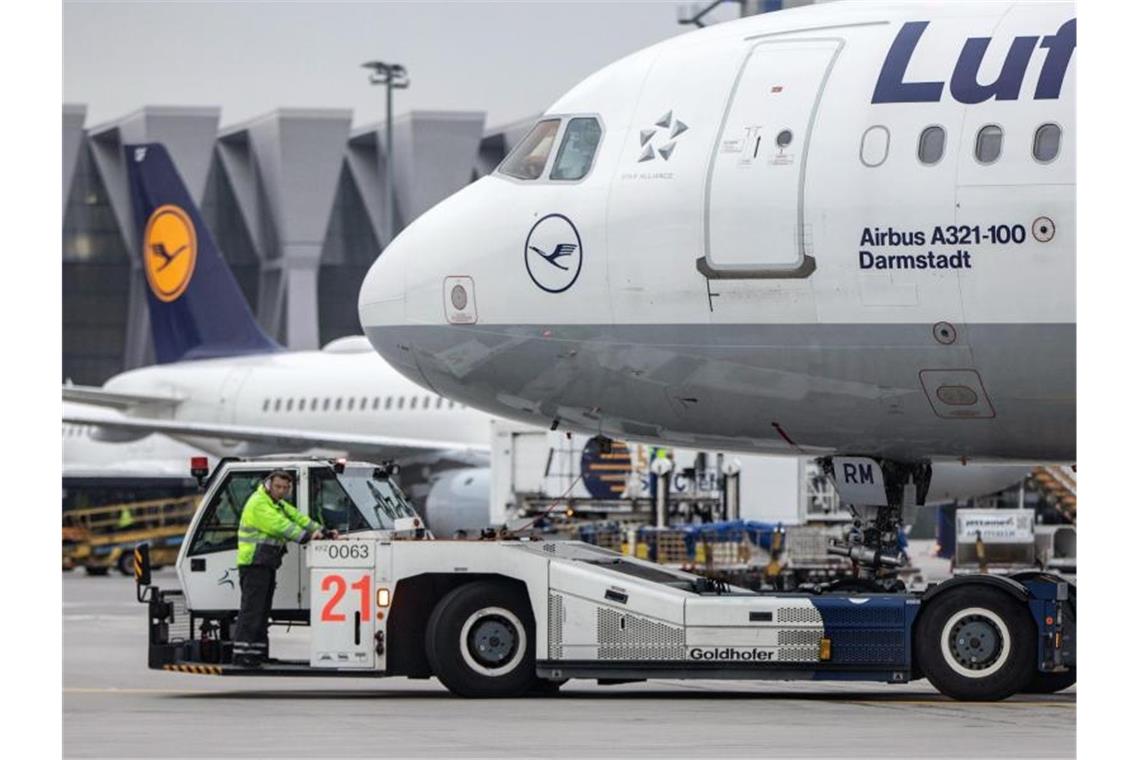 Ein Diesel-Schlepper zieht einen Airbus der Lufthansa von seiner Position am Fluggaststeig in Frankfurt. Foto: Frank Rumpenhorst/dpa