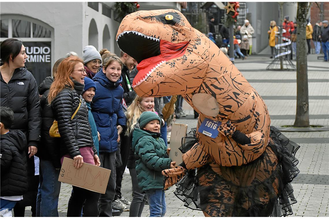 Ein Dinosaurier und die Zuschauer haben richtig Spaß bei der Veranstaltung.