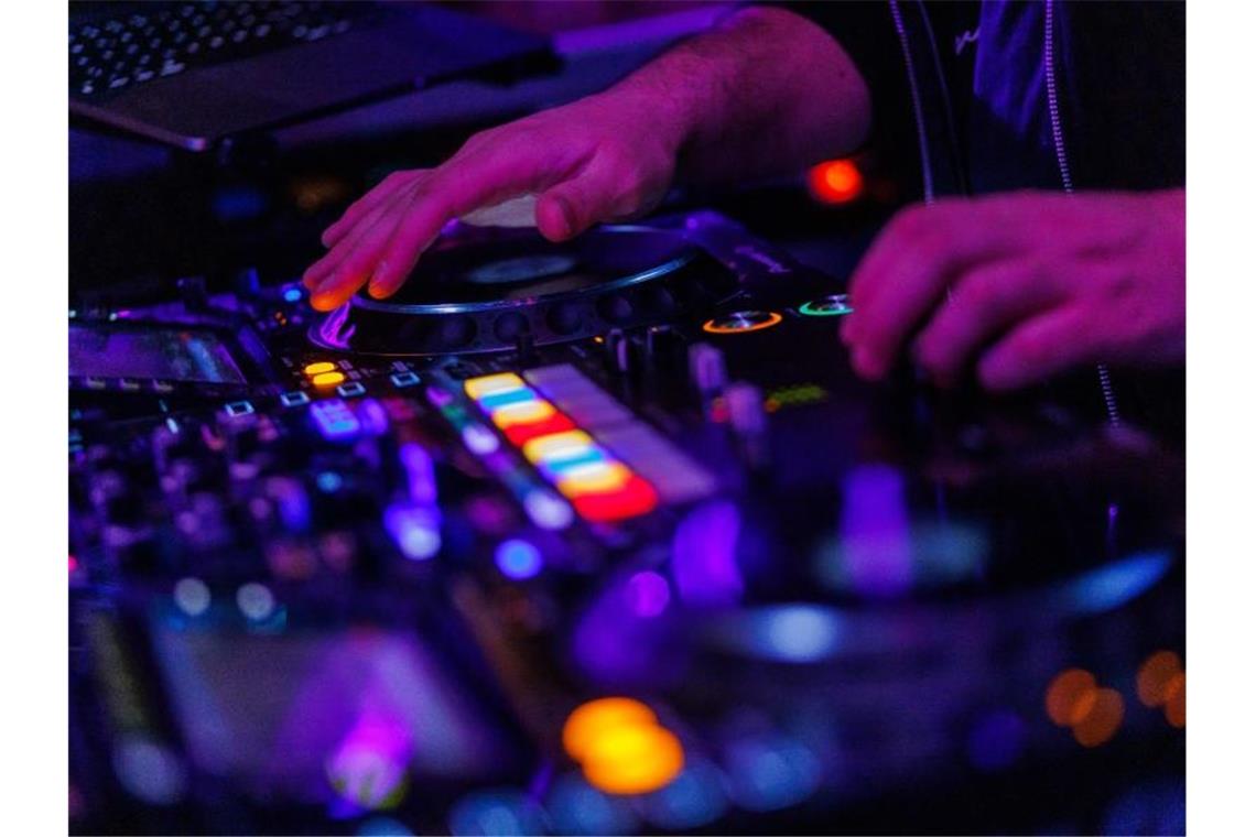 Clubs wollen nicht als Pandemietreiber gebrandmarkt werden Ein DJ steht in einem Club am Mischpult. Foto: Philipp von Ditfurth/dpa/Symbolbild