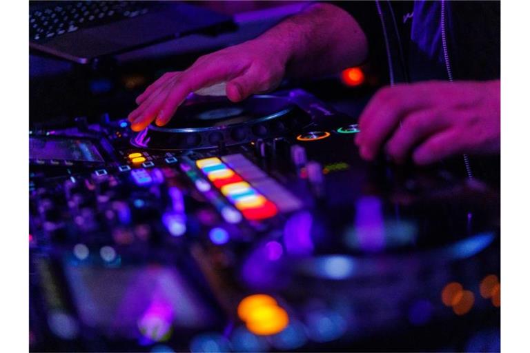 Ein DJ steht in einem Club am Mischpult. Foto: Philipp von Ditfurth/dpa/Symbolbild