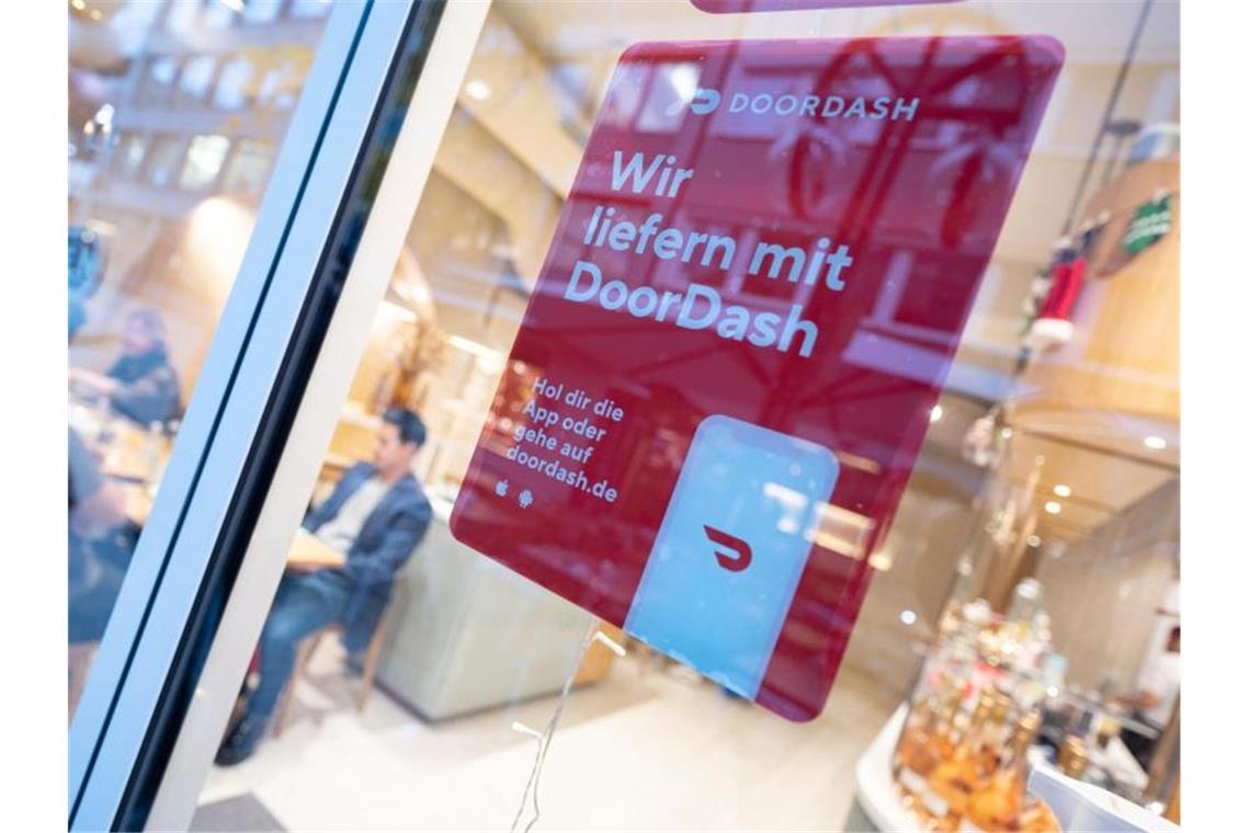 DoorDash startet Deutschland-Geschäft in Stuttgart Ein DoorDash-Plakat hängt an einer Scheibe des Restaurants „Masseria“. Foto: Marijan Murat/dpa