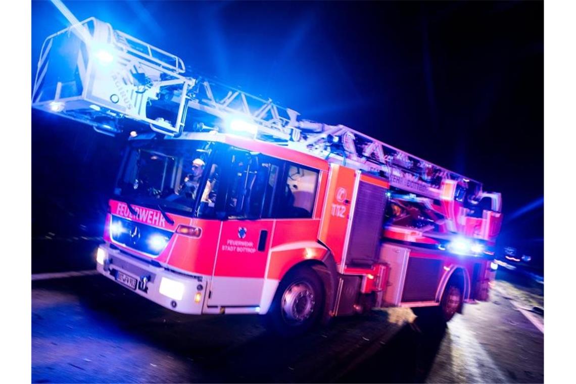 Hochhaus wegen Balkonbrand evakuiert: Ein Verletzter Ein Drehleiterwagen der Feuerwehr fährt mit Blaulicht an einer Unfallstelle vorbei. Foto: Marcel Kusch/dpa/Illustration