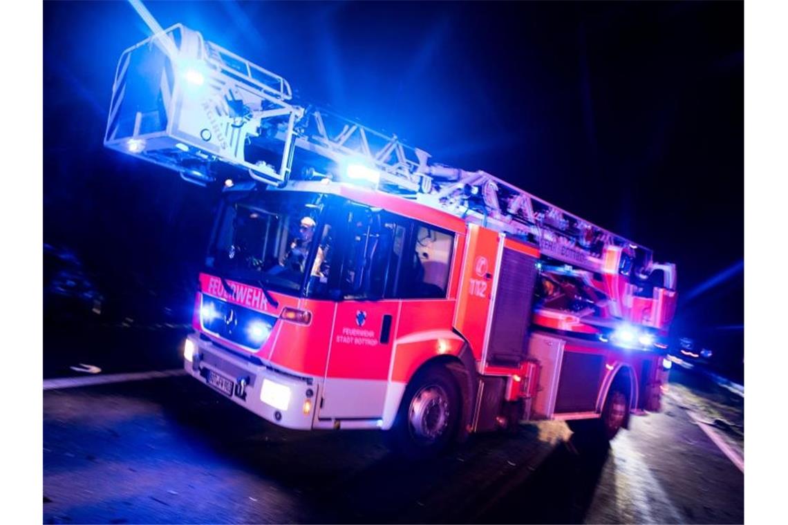 Ein Drehleiterwagen der Feuerwehr fährt mit Blaulicht zu einem Einsatz. Foto: Marcel Kusch/dpa/Archivbild