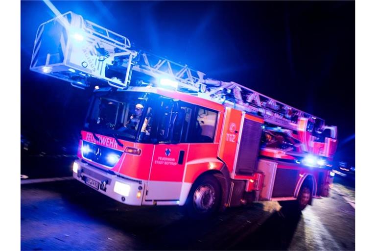 Ein Drehleiterwagen der Feuerwehr fährt mit Blaulicht zu einem Einsatz. Foto: Marcel Kusch/dpa/Archivbild