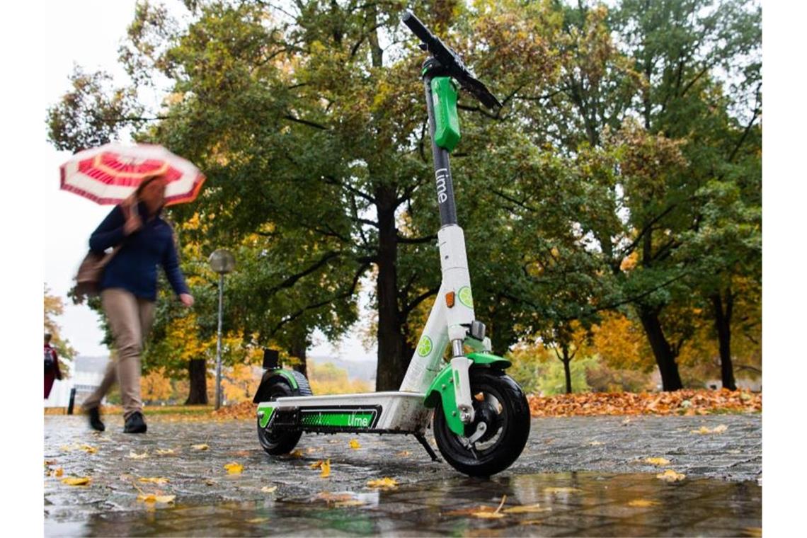 Ein E-Scooter steht im Herbst bei Regen im Oberen Schlossgarten in Stuttgart. Foto: Tom Weller/Archiv