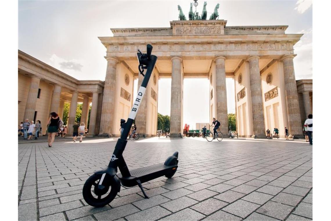 Ein E-Tretroller des Anbieters Bird steht vor dem Brandenburger Tor. Die US-Firma, die bereits in 140 Städten weltweit aktiv ist, startet an diesem Montag in Berlin, Hamburg, Ko¨ln, Frankfurt und Mu¨nchen mit zunächst jeweils 100 Scootern. Foto: Bird/Handout