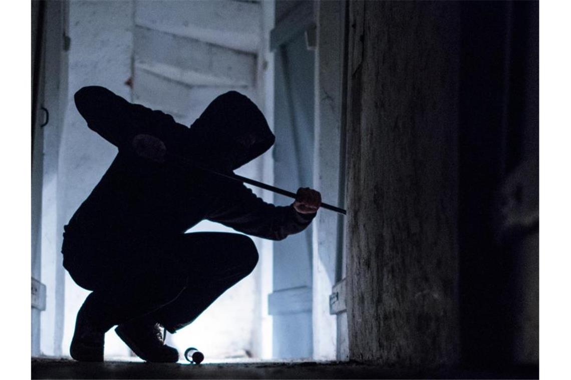 Einbrecher knacken Tresor und stehlen Waffen Ein Einbrecher benutzt ein Brecheisen, um eine Tür zu öffnen. Foto: Silas Stein/dpa/Symbolbild