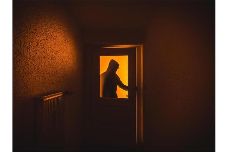 Ein Einbrecher verschafft sich Zutritt zu einer Wohnung. Foto: Nicolas Armer/Archivbild