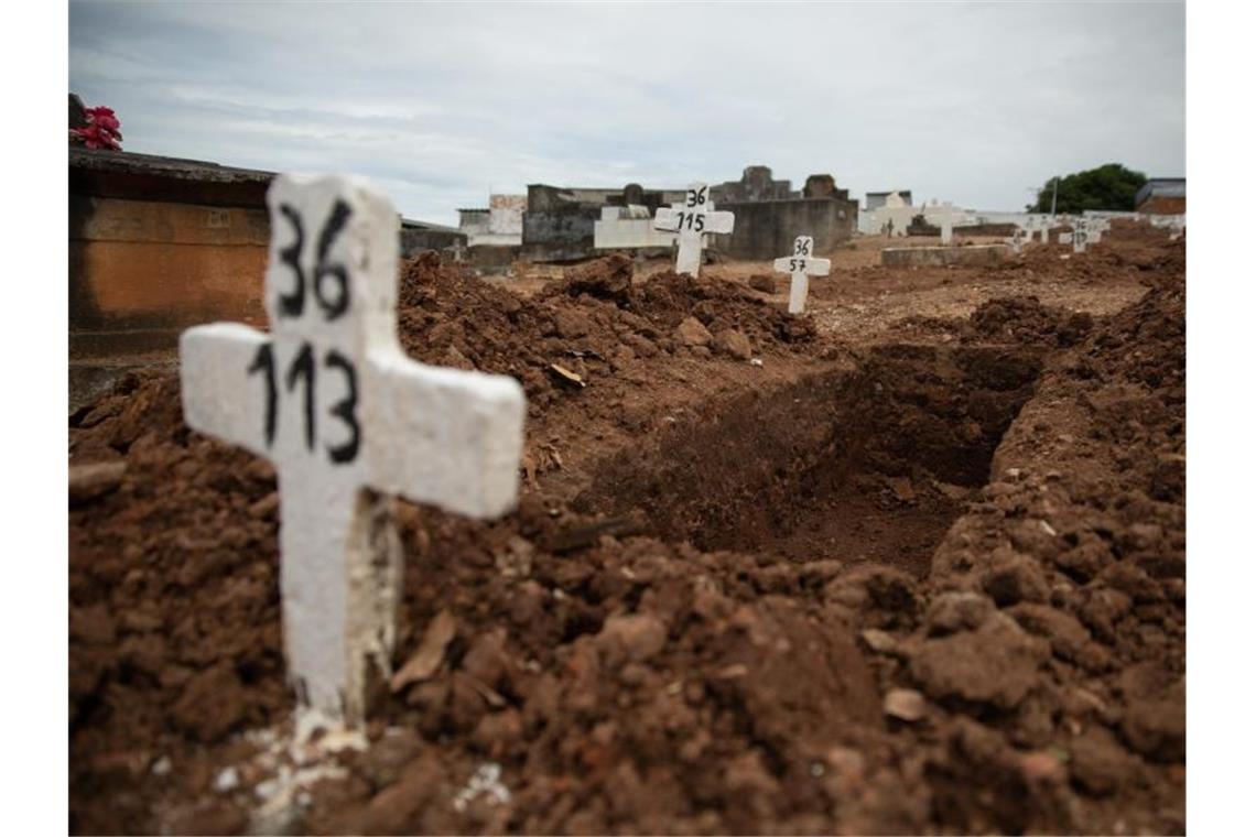 Brasilien auf dem Höhepunkt der Pandemie Ein einfaches Kreuz ohne Namen und mit einer Nummer steht an einem offenen Grab am Friedhof von Iraja in Rio de Janeiro. Foto: Fernando Souza/dpa