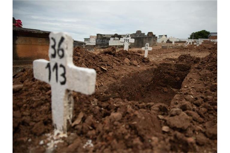 Ein einfaches Kreuz ohne Namen und mit einer Nummer steht an einem offenen Grab am Friedhof von Iraja in Rio de Janeiro. Foto: Fernando Souza/dpa
