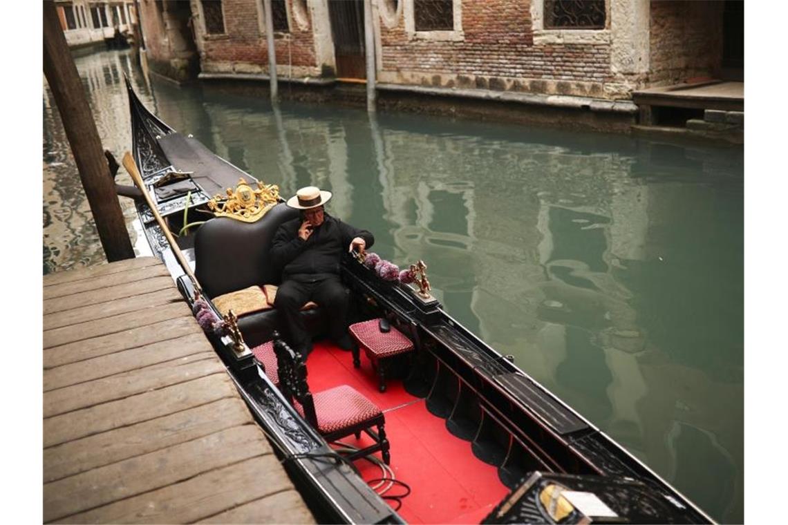Ein einsamer Gondoliere wartet in Venedig auf Kunden. Der Ausbruch des Coronavirus beeinträchtig den Tourismus in Italien. Foto: Francisco Seco/AP/dpa