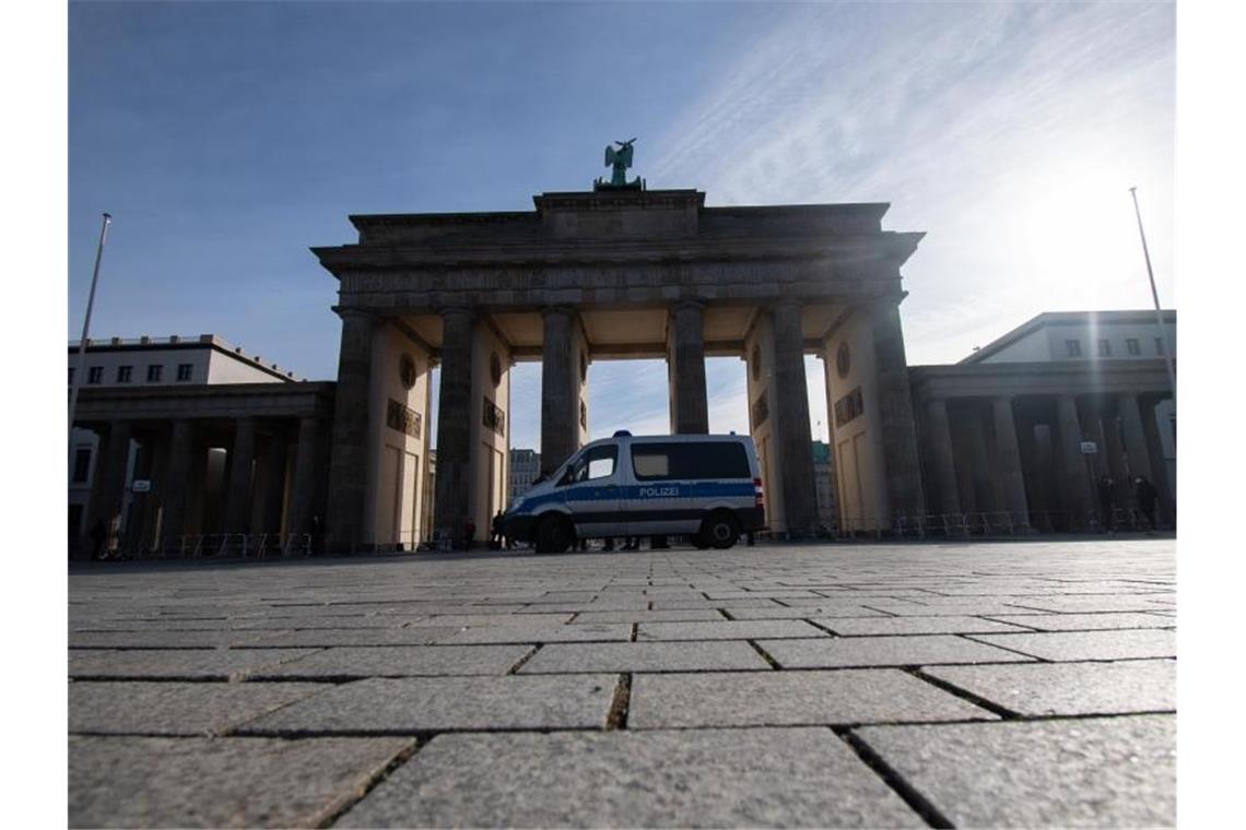 Ein Einsatzwagen der Polizei steht am Brandenburger Tor. Rund um das Brandenburger Tor wollen am Samstag Rechtsextreme und "Reichsbürger" demonstrieren. Foto: Paul Zinken/dpa-Zentralbild/dpa