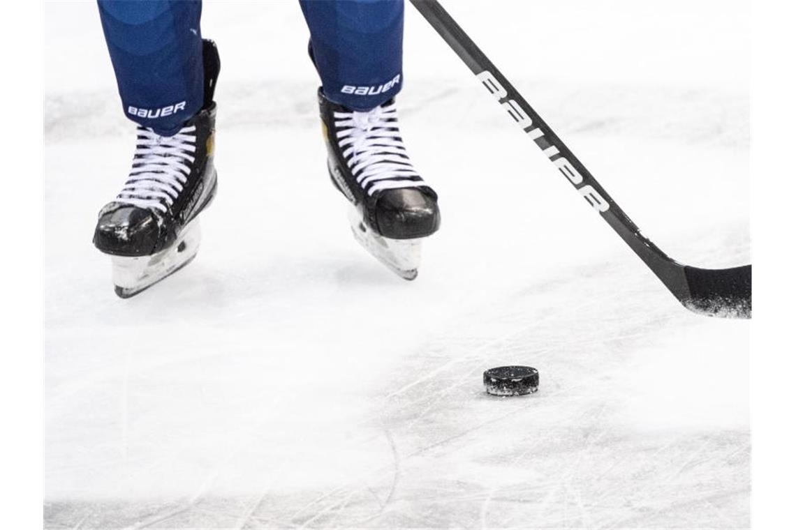 Ein Eishockeyspieler spielt den Puck. Foto: Matthias Balk/dpa/Symbolbild