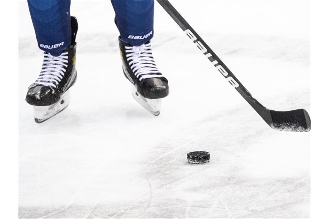 Impfungen bei Schwenninger Wild Wings: Spielverlegung in DEL Ein Eishockeyspieler spielt den Puck. Foto: Matthias Balk/dpa/Symbolbild