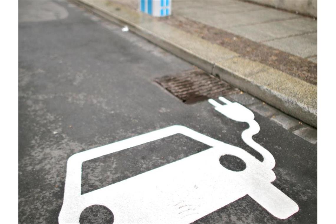 Ein Elektrofahrzeug kennzeichnet einen Parkplatz neben einer Ladesäule an einer Straße. Foto: Jan Woitas/dpa-Zentralbild/dpa