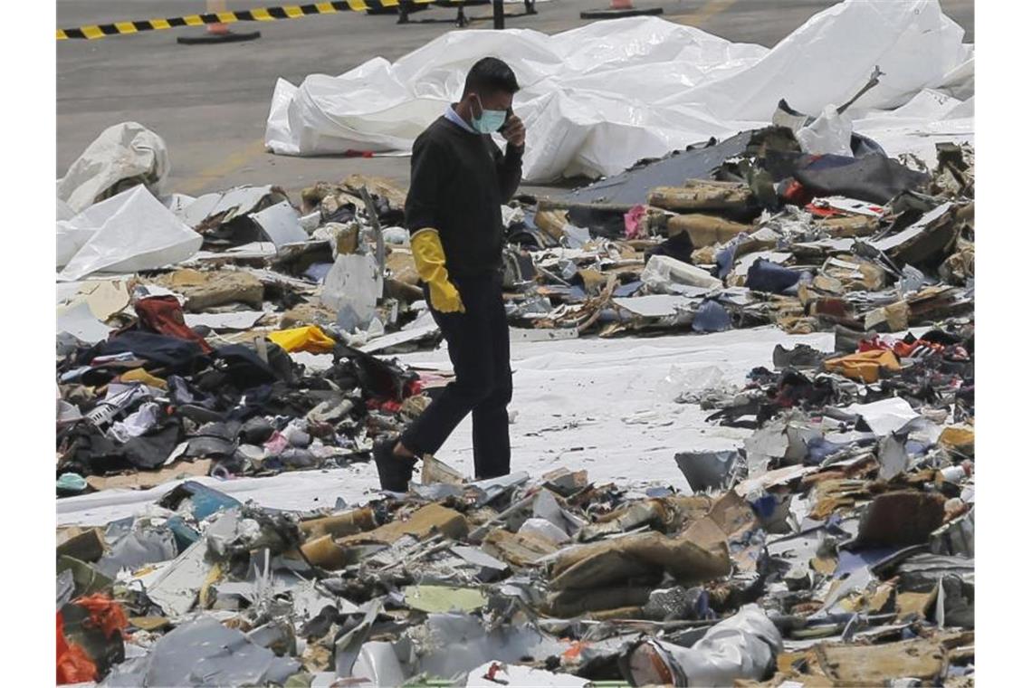 Bericht macht Boeing für Lion-Air-Absturz verantwortlich Ein Ermittler inmitten von Trümmern der Boeing 737 Max von Lion Air. Foto: Tatan Syuflana/AP/dpa